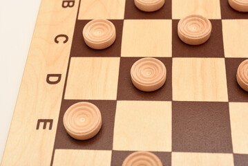 Wooden checkers on the board. The board game checkers.