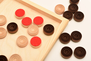 Wooden checkers on the board. The board game checkers.