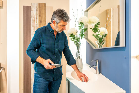 Architect checking bathroom sink in home improvement store with tablet