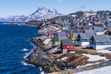 Scenic view of colorful houses nestled along the coast of Nuuk, Greenland, with Sermitsiaq mountain in the background