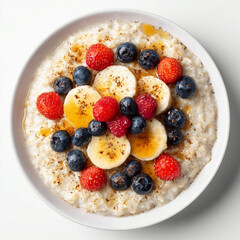 A plate of porridge with different berries and fruits isolated on a white background, top view