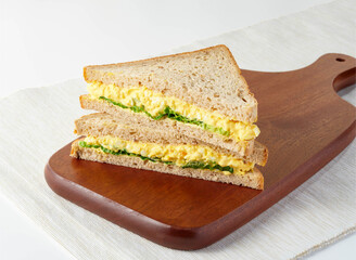 Classic Egg Mayo Sandwich on Whole Wheat Bread isolated on wooden board side view of Perfect for Quick Lunch or Snack
