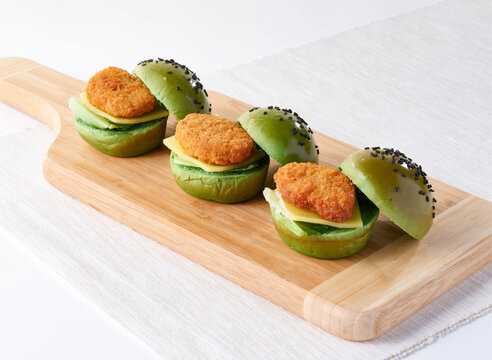 Mini Impossible Chicken Nuggets Matcha Burgers Green Buns, Crispy Nuggets and Cheese on wooden board side view of lunch menus
