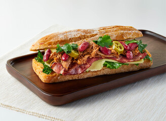 Slow-Cooked Mexican Trio Pork Ciabatta Sandwich with Beans, Jalapenos and Cilantro on Wooden Board Side View of breakfast or lunch menus