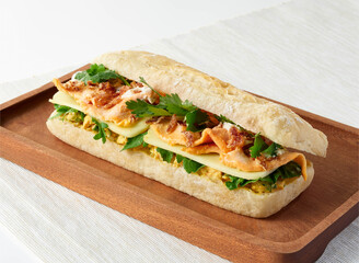 Delicious Chicken Tandoori and Curry Madras Ciabatta Sandwich on wooden board side view of Savory Lunch or Dinner