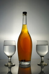 Refined Still Life Featuring Amber Liquor Bottle and Empty Elegant Glasses Arrangement