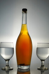 Sophisticated spirits presentation featuring a bottle of amber liquid alongside two elegant stemmed glasses
