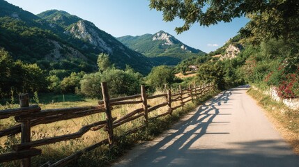 Country road lined with rustic wooden fences stretching into lush green countryside