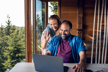 Couple video calling family from cabin in the woods