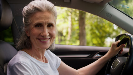 Happy smiling Caucasian mature senior elderly woman female auto owner lady grandmother automobile...