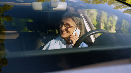 Laughing cheerful Caucasian elderly business woman car taxi driver auto owner mature businesswoman...