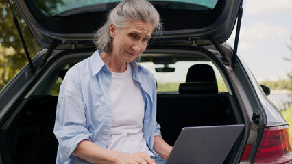 Confused upset Caucasian mature elderly woman female elderly lady freelancer user sit car...