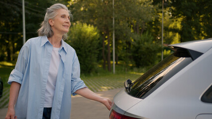 Happy elderly Caucasian shopper woman shopaholic female senior mature customer consumer automobile...