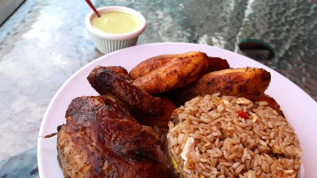 peruvian fried chicken dish with pork and egg fried rice fried sweet plantains and spicy green sauce (peru cuisine restaurant special meal ossining new york) white plate rotisserie pollo asian fusion