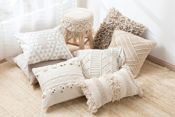 Cozy autumn-inspired arrangement of textured neutral throw pillows with bohemian embroidery and...