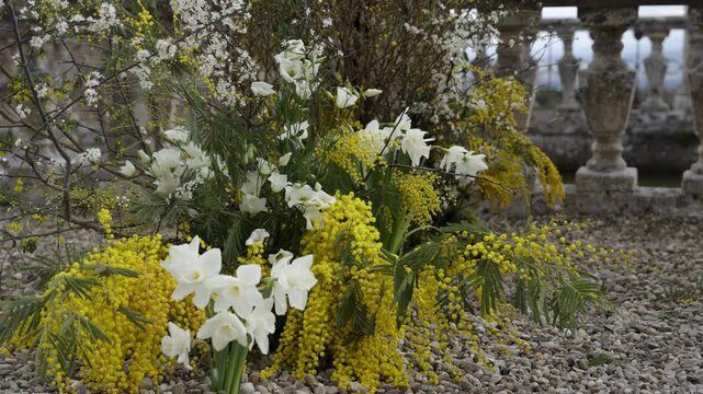 Spring flowers adorning a gravel path near a stone balustrade. Action