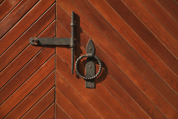 Ancient metal round gate arm and bolt, brown wooden background