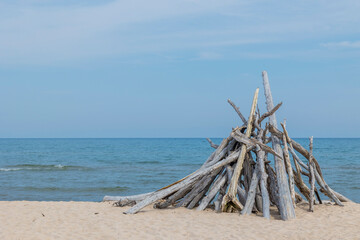 Driftwood stacked for a large bonfire on a beach. 