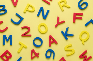 Colorful foam letters and numbers on yellow background.