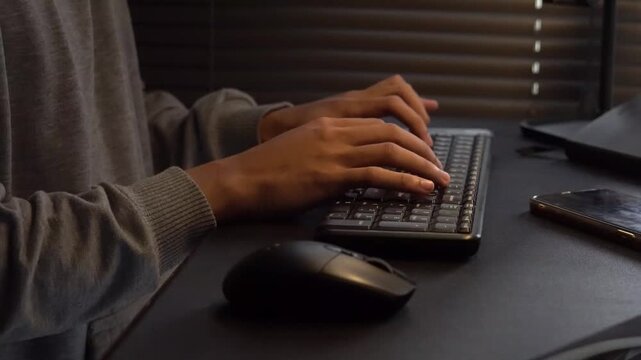 Hands typing on a computer keyboard with a mouse, illustrating productivity and remote work in a modern office setting.