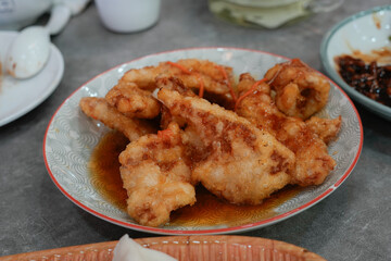A plate of Guo Bao Rou, a classic Northern Chinese dish featuring crispy, deep-fried pork in a sweet and sour sauce