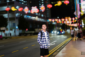 a young man standing on a street at night showing of a night bokeh photography