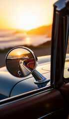 Matahari terbenam keemasan di atas laut tercermin di kaca spion bulat mobil di tepi pantai