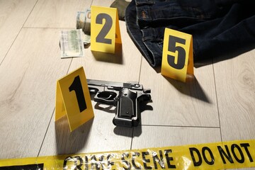 Forensic expertise. Crime scene with evidence, markers and police tape on floor, closeup