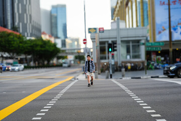 a man walking across a street in singapore