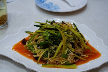 fresh vegetable salad with spicy dressing served on a white plate