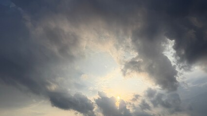 Sunlight filters through a gap in the dramatic, overcast sky before a potential storm