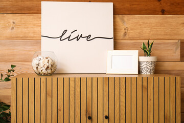 Stylish cabinet with decor near wooden wall