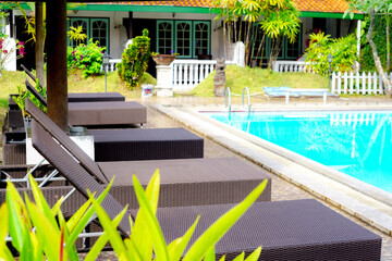 Serene tropical resort with a swimming pool and sun loungers. Ideal for illustrating vacations, relaxation, and hotel amenities