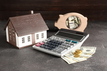 House model, calculator and money on black background