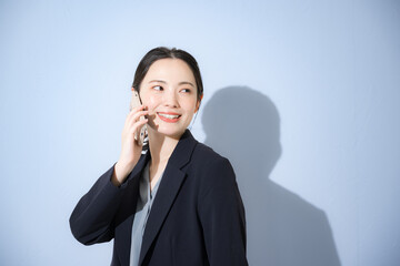 電話をかける通話するスーツを着た若い女性のビジネスシーン