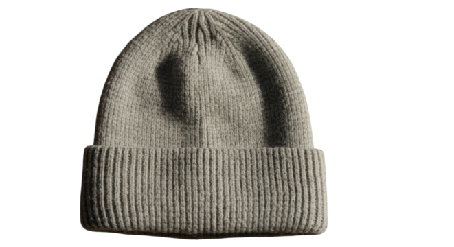 A single, folded, knitted beanie hat in a neutral beige color, isolated on a clean white background.