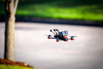 FPV quadcopter flying in a park with an action camera. This is a 5 inch racing drone.