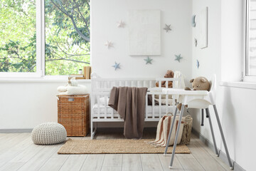 Interior of light children's bedroom with crib, toy stars and teddy bears