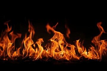 Fototapeta premium A display of flickering orange flames dancing over a dark undefined base