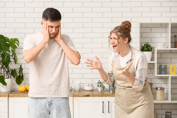 Unhappy couple quarreling in kitchen
