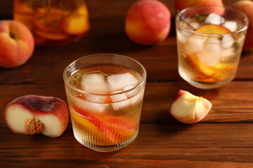 Glasses of fresh peach lemonade and fruits on wooden background, closeup