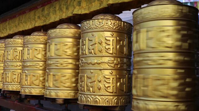 Rotating brass prayer wheels in Nepal monastery. Buddhist symbols, mantra engraving, spinning motion, cultural heritage, traditional ritual, spiritual architecture, Himalayas stock video