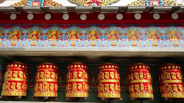 Rotating brass prayer wheels in Nepal monastery. Buddhist symbols, mantra engraving, spinning motion, cultural heritage, traditional ritual, spiritual architecture, Himalayas stock video