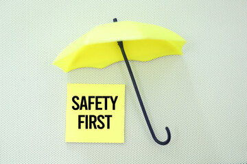 hands holding a car steering wheel and paper with the word SAFETY FIRST. the main concept of safety in driving