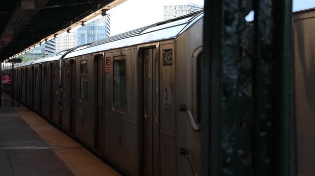 subway train passing elevated stop platform in queens (7 cars apartment buildings background) outdoor station nyc new york city flushing park