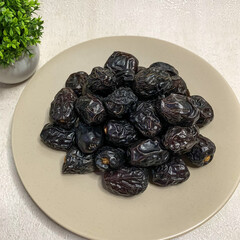 A bountiful plate of authentic Ajwa dates, known for their unique dark color and rich flavor.