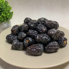 A bountiful plate of authentic Ajwa dates, known for their unique dark color and rich flavor.