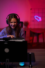 Asian female gamer streaming online video games intense gameplay from home setup illuminated neon...