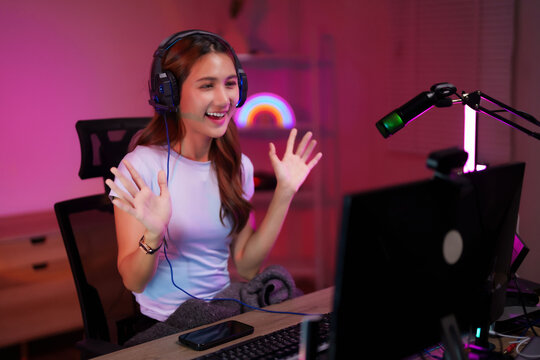 Asian young adult woman gamer streamer live broadcasting video game online at home