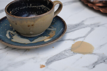 Coffee spills while resting on a marble table surface